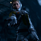 Selene extends a hand toward the camera at night time in Returnal.